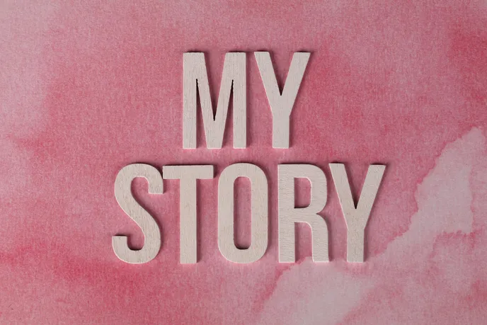 The words 'MY STORY' displayed on a pink watercolor background, representing personal narratives and journeys.