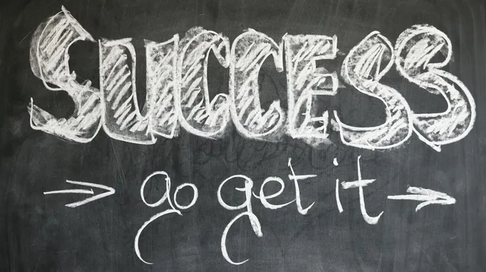 A motivational chalkboard displaying the text 'SUCCESS' in large, bold letters, with the phrase 'go get it' written below in a more elegant script. The overall design evokes a feeling of inspiration and drive.